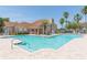 Resort style pool, surrounded by palm trees and community clubhouse at 10502 Villa View Cir, Tampa, FL 33647
