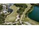 Aerial view of a golf course featuring a pond, sand traps, and mature trees at 10517 Palm Cove Ave, Tampa, FL 33647