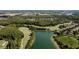 Aerial view of a golf course community with a lake, lush trees, and manicured green fairways at 10517 Palm Cove Ave, Tampa, FL 33647