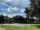 Community basketball court next to a clubhouse surrounded by lush trees in a well maintained grassy area at 10517 Palm Cove Ave, Tampa, FL 33647
