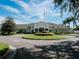 Community clubhouse with well-maintained landscaping, circular driveway, and an American flag flying overhead at 10517 Palm Cove Ave, Tampa, FL 33647