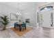 Dining area with a chandelier, a wood table with teal chairs, gray walls, and luxury vinyl plank flooring at 10517 Palm Cove Ave, Tampa, FL 33647