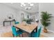 Open-concept dining room featuring a wooden table, blue chairs and modern lighting at 10517 Palm Cove Ave, Tampa, FL 33647