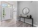 Bright entryway with sleek gray flooring, a console table with a mirror, and a front door with transom windows at 10517 Palm Cove Ave, Tampa, FL 33647
