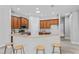 Charming kitchen features breakfast bar with stools and wood cabinets with modern appliances at 10517 Palm Cove Ave, Tampa, FL 33647