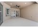Wide, open lanai with ceiling fan, sliding glass doors, and textured exterior paint at 10517 Palm Cove Ave, Tampa, FL 33647