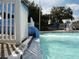 Water slide splashes into a community pool with 3 ft depth marker in a tropical landscaped area for residents enjoyment at 10517 Palm Cove Ave, Tampa, FL 33647