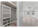 Walk-in closet featuring shelving and hanging space, connecting to the main bedroom at 10517 Palm Cove Ave, Tampa, FL 33647