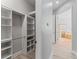 Spacious walk-in closet with custom shelving, providing ample storage space, leading into bathroom at 10517 Palm Cove Ave, Tampa, FL 33647