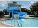 Community pool featuring a water slide and poolside access, all set in a tropical landscaped area for residents enjoyment at 10517 Palm Cove Ave, Tampa, FL 33647