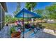 Landscaped backyard with a canopy over outdoor furniture, a fire pit, and distant pool at 12923 Colony Rd, Hudson, FL 34669