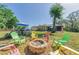 This backyard features a fire pit surrounded by colorful chairs and an above-ground pool for outdoor entertainment at 12923 Colony Rd, Hudson, FL 34669