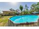 Backyard with a refreshing above-ground pool and lush green surroundings for outdoor enjoyment at 12923 Colony Rd, Hudson, FL 34669