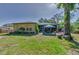 This backyard features a screened-in porch adjacent to a patio and is partially shaded by a mature tree at 12923 Colony Rd, Hudson, FL 34669