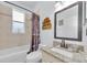 This full bathroom includes a granite countertop, vanity mirror and tiled shower and tub combo at 12923 Colony Rd, Hudson, FL 34669