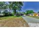 Exterior view of home with mature trees, a long driveway, and an attached two car garage at 12923 Colony Rd, Hudson, FL 34669