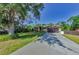 Exterior view of a single-Gathering home with a well-maintained lawn, mature trees, and a long driveway at 12923 Colony Rd, Hudson, FL 34669