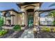 Home's front door framed by decorative columns and lush plants for privacy at 12923 Colony Rd, Hudson, FL 34669