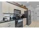 Open kitchen boasts granite countertops, stainless steel appliances, and stylish cabinets at 12923 Colony Rd, Hudson, FL 34669