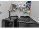 Organized laundry room featuring front load washer and dryer units and shelving with cleaning and laundry supplies at 12923 Colony Rd, Hudson, FL 34669