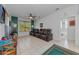 Bright living room featuring leather furniture, colorful walls, and access to bathroom at 12923 Colony Rd, Hudson, FL 34669