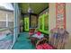 Charming outdoor patio featuring vibrant tiki decor, green doors, and unique furniture at 12923 Colony Rd, Hudson, FL 34669