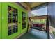 Enclosed patio displaying a swing, green doors, and views of the landscaped backyard at 12923 Colony Rd, Hudson, FL 34669