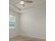 The bedroom features a tray ceiling, neutral carpet, and a bright window at 13637 Blythewood Dr, Spring Hill, FL 34609