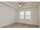 The bedroom features tray ceilings and natural light from the two bright windows at 13637 Blythewood Dr, Spring Hill, FL 34609