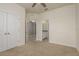 This bedroom features neutral carpet, ceiling fan, and a glimpse into the attached bathroom at 13637 Blythewood Dr, Spring Hill, FL 34609
