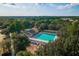 Aerial view of a community pool, clubhouse and playground, showing ample space for outdoor recreation and community gatherings at 13637 Blythewood Dr, Spring Hill, FL 34609
