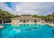 Reflective community pool and recreation center offering a refreshing oasis for residents to enjoy under clear skies at 13637 Blythewood Dr, Spring Hill, FL 34609