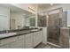 Main bathroom with double vanity sinks, granite countertops, and a glass-enclosed shower at 13637 Blythewood Dr, Spring Hill, FL 34609
