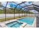 Beautiful backyard pool with spa and full screen enclosure provides privacy and protection from the elements at 13637 Blythewood Dr, Spring Hill, FL 34609