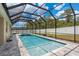 Outdoor screened-in pool and hot tub, with brick-paver deck and a privacy fence at 13637 Blythewood Dr, Spring Hill, FL 34609