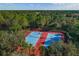 Aerial view of the community's tennis courts that are well-maintained, and surrounded by mature trees at 13637 Blythewood Dr, Spring Hill, FL 34609