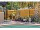 Backyard with a beautiful pool, landscaped fence, and cozy sitting area with mushroom decor at 13880 Dominica Dr, Seminole, FL 33776