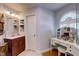 Bathroom featuring vanity, glass enclosed shower, built-in vanity with a dressing table and arched window at 1416 Buckner Rd, Valrico, FL 33596