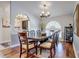Bright dining room featuring hardwood floors, a wooden table with seating for six, and an arched entryway at 1416 Buckner Rd, Valrico, FL 33596