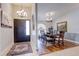 Elegant foyer leading to a dining room with hardwood floors, chandelier, and natural light from a large window at 1416 Buckner Rd, Valrico, FL 33596