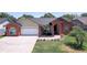Inviting single-story home with brick accents, manicured lawn, and a spacious driveway leading to an attached garage at 1416 Buckner Rd, Valrico, FL 33596