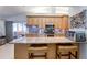 Modern kitchen with light wood cabinets, stainless steel appliances and granite countertops with bar seating at 1416 Buckner Rd, Valrico, FL 33596
