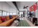 Spacious sunroom featuring an orange couch, a football rug, and Buccaneers decor at 1416 Buckner Rd, Valrico, FL 33596