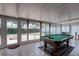 Bright sunroom featuring tile flooring, a billiard table, and an abundance of natural light at 1416 Buckner Rd, Valrico, FL 33596
