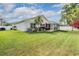 Spacious backyard with an enclosed patio, tropical landscaping, and pristine grass at 14920 Rocky Ledge Dr, Tampa, FL 33625