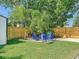 Inviting backyard fire pit area with Adirondack chairs and a lush tropical landscape at 1600 Pasadena Dr, Dunedin, FL 34698
