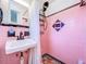 Retro pink-tiled bathroom with shower, vanity, and black and white tiled floors at 1600 Pasadena Dr, Dunedin, FL 34698
