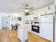 Open kitchen design featuring white cabinetry, stainless steel appliances, and wood flooring, blending style with functionality at 1600 Pasadena Dr, Dunedin, FL 34698