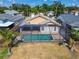 A backyard featuring a screened pool enclosure, with a well-maintained lawn and palm trees for privacy and shade at 1601 Westerly Dr, Brandon, FL 33511