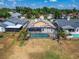 Backyard aerial view shows the screened-in pool, wooden fence, and expansive lawn with neighboring houses nearby at 1601 Westerly Dr, Brandon, FL 33511